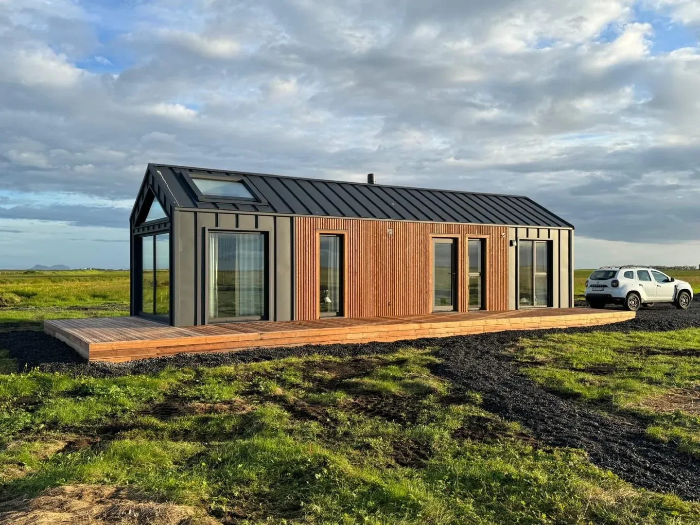 A built Bouw Art modular house with timber and black cladding in an open landscape